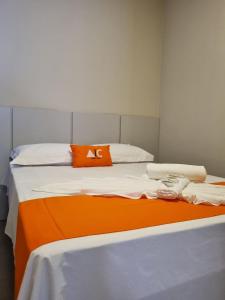 an orange and white bed in a room at 1- ACHEI Casa - Seu espaço preferido em Porto Velho in Porto Velho
