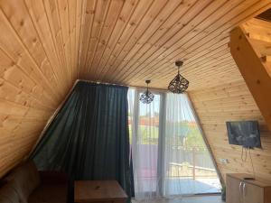 a room with a large window in a wooden ceiling at Demetra in Buknari +6 photos