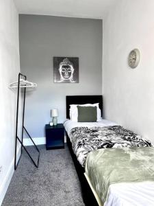 Outdoor Patio, Near Stadium Of Light, Refurbished في Monkwearmouth: غرفة نوم بسريرين وساعة على الحائط