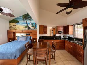 a bedroom with a bed and a kitchen with a table at Tropical Beach Second Floor Studio with Hill view in Coco