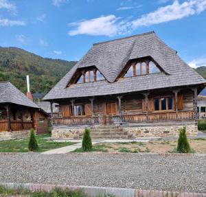 a log cabin with a slate roof at Emma's Lake Houses in Bîrsana