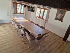 a conference room with a long wooden table and chairs at Emma's Lake Houses in Bîrsana