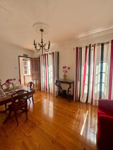 a living room with a table and chairs and a chandelier at Casa da Villa 1A in Sintra +10 photos