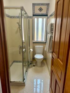 a bathroom with a toilet and a glass shower at Casa da Villa 1A in Sintra