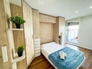 una camera da letto con un letto con una coperta blu di El Olivo del Pilar Turistea a Saragozza