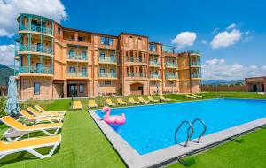 a hotel with a swimming pool in front of a building at Burki Castle & Cellar in Kvareli