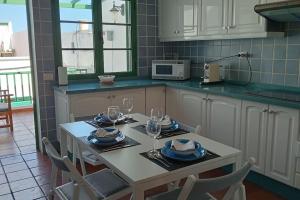 a kitchen with a table with plates and wine glasses at famarabeach2 in Famara