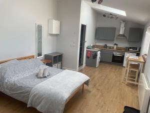 ein Schlafzimmer mit großem Bett und eine Küche in der Unterkunft The Milking Sheds in Tytherington + 8 Fotos