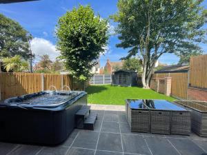un cortile con vasca idromassaggio e due tavoli da picnic di Amber House a Gorleston-on-Sea