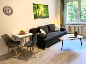 a living room with a couch and a table and chairs at Moderne Studio-Apartments in Wolfen in Steinfurth