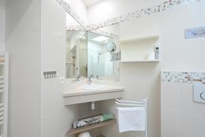 een witte badkamer met een wastafel en een spiegel bij Cocon Douillet, plages à 2 pas in La Noue +19 foto's