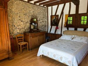 a bedroom with a bed and a vanity and a mirror at Les Côtières in Maresville