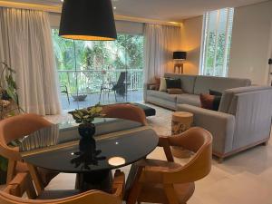 布卢梅瑙HolzHaus Blumenau的客厅里有一张沙发、一张桌子和几把椅子。