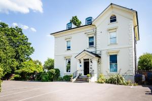 a white house with a driveway in front of it at Beaumont House in Cheltenham