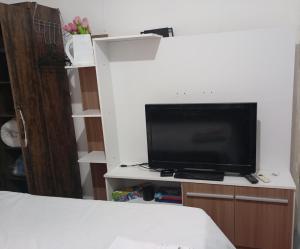 a tv on a stand in a room at Apto Casa A Simples, Central e Aconchegante in Corumbá