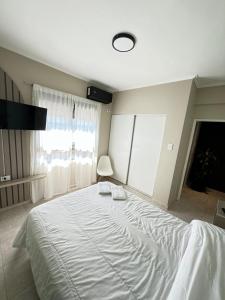 ein Schlafzimmer mit einem großen weißen Bett und einem Fenster in der Unterkunft Departamento Exclusivo frente al puerto con cochera in Santa Fe