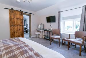 a bedroom with a bed and a desk and a television at Tyn Llain B&B in Llanfflewyn
