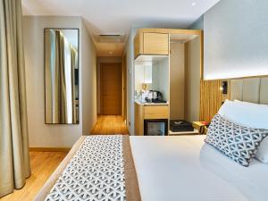 Un dormitorio con una gran cama blanca y una cocina. en Thank You Hotel Sultanahmet, en Estambul