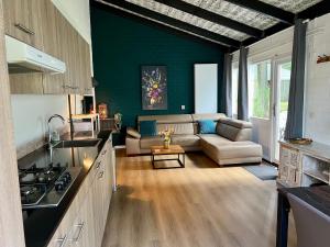 a kitchen and a living room with a couch at Gehele Bungalow zuid-Limburg op een park in Simpelveld