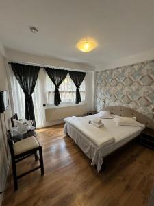 a bedroom with a large bed and a chair at Casa David in Buşteni