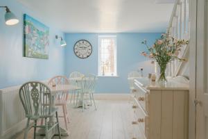 a dining room with a table and chairs and a clock at Tyn Llain B&B in Llanfflewyn