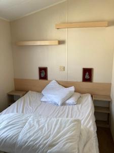 a bed with white sheets and two pillows on it at Luxury 8 and 6 berth caravans in Jaywick Sands