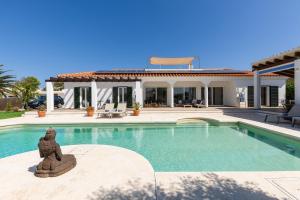 a house with a swimming pool in front of a house at Villa Maravilla with HEATABLE pool ROOFTOPbar with sea views in Binibeca
