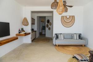 a living room with a couch and a flat screen tv at KUDOS Beach Apartments Jambiani in Jambiani