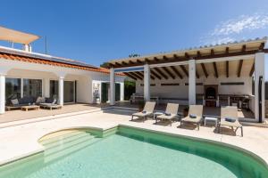 a villa with a swimming pool and a patio at Villa Maravilla with HEATABLE pool ROOFTOPbar with sea views in Binibeca