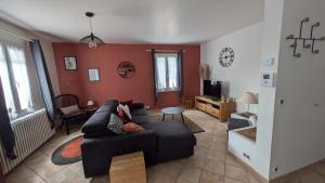 a living room with a black couch and red walls at Chez Pascaline in Nyons