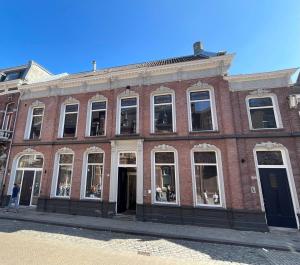 a red brick building with many windows on a street at HotelBed w aircon at City Villa Tilburg Willem 1 in Tilburg