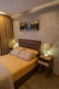 een slaapkamer met een bed en een nachtkastje met 2 lampen bij Dpto ejecutivo y lujoso con una explendida vista! in El Pary