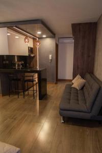 een woonkamer met een bank en een keuken bij Dpto ejecutivo y lujoso con una explendida vista! in El Pary