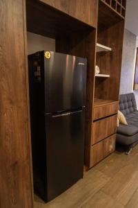 een zwarte koelkast in een keuken met een bank bij Dpto ejecutivo y lujoso con una explendida vista! in El Pary +34 foto's