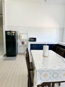 a kitchen with a table and a black refrigerator at QU Homestay Kuala Terengganu in Kuala Terengganu