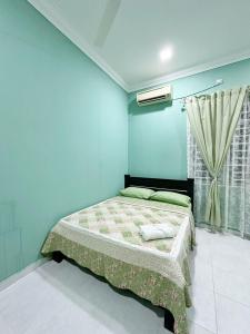 a bedroom with a bed with blue walls and a window at QU Homestay Kuala Terengganu in Kuala Terengganu