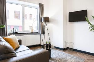 a living room with a couch and a window at Spacious City Loft With Balcony & High-speed Wi-fi in Tilburg +30 photos