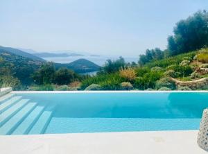 a swimming pool with a view of a mountain at The Cove Sivota Bay in Sivota