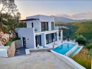 a villa with a swimming pool and a house at The Cove Sivota Bay in Sivota