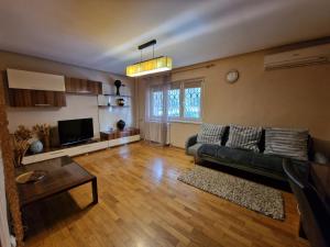 a living room with a couch and a television at Apartment Central in Constanţa