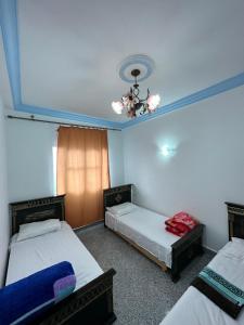 a room with two beds and a ceiling at Casa Sharawy in Chefchaouene