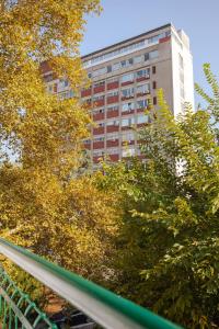 a tall building in the distance with trees in the foreground at Apartment Lea in Belgrade