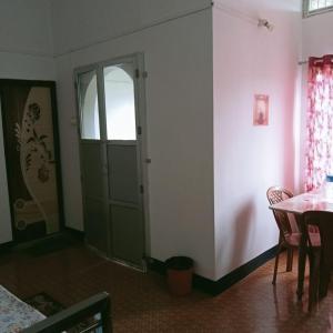 a room with a table and a door and a table and chairs at Panchalaya Homestay in Guwahati