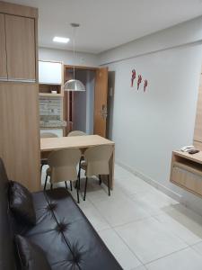 a kitchen and dining room with a table and chairs at Everest Flat Conforto, Lazer e Localização Central in Caldas Novas