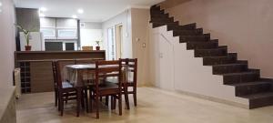 里瓦达维亚海军准将城Moderno Duplex 1 - Alquiler en Comodoro Rivadavia的用餐室以及带桌子和楼梯的厨房
