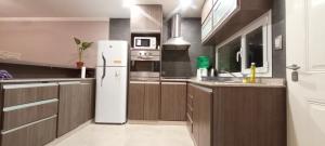 a kitchen with a white refrigerator and wooden cabinets at Moderno Duplex 1 - Alquiler en Comodoro Rivadavia in Comodoro Rivadavia