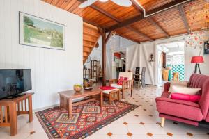 a living room with a couch and a tv at Villa Maracudja in Saint-François