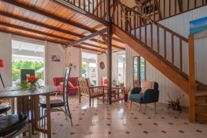 a living room with a staircase and a table and chairs at Villa Maracudja in Saint-François +20 photos