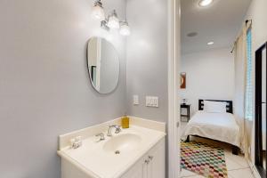 a bathroom with a sink and a mirror and a bed at Pineapple Place in Fort Lauderdale +17 photos
