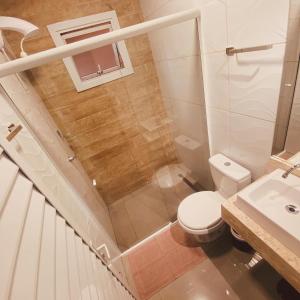 a small bathroom with a toilet and a sink at Angico Motel in Passo Fundo